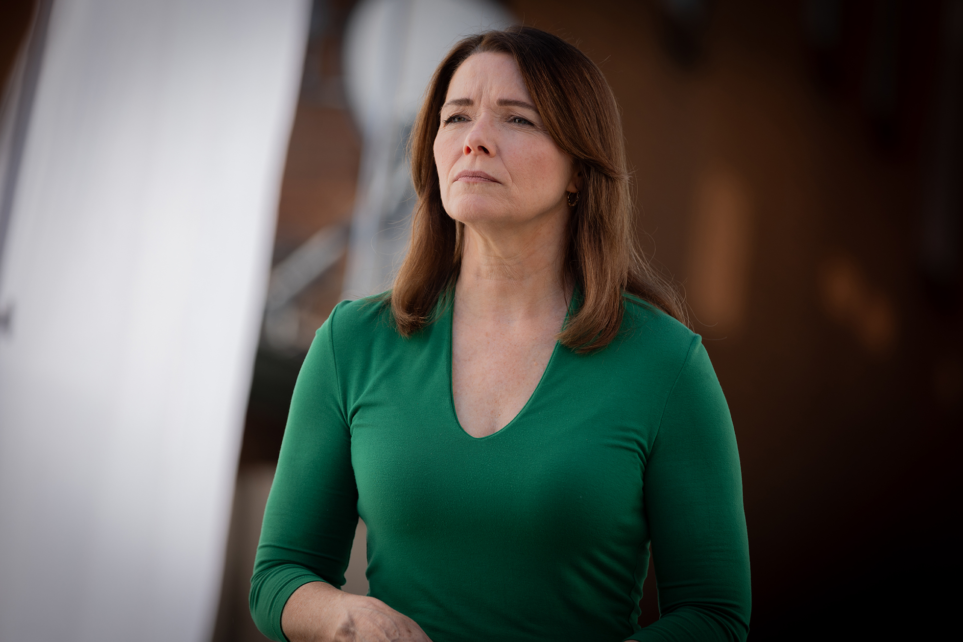 Christina Bohannan in a green top with a serious expression standing outdoors in soft light